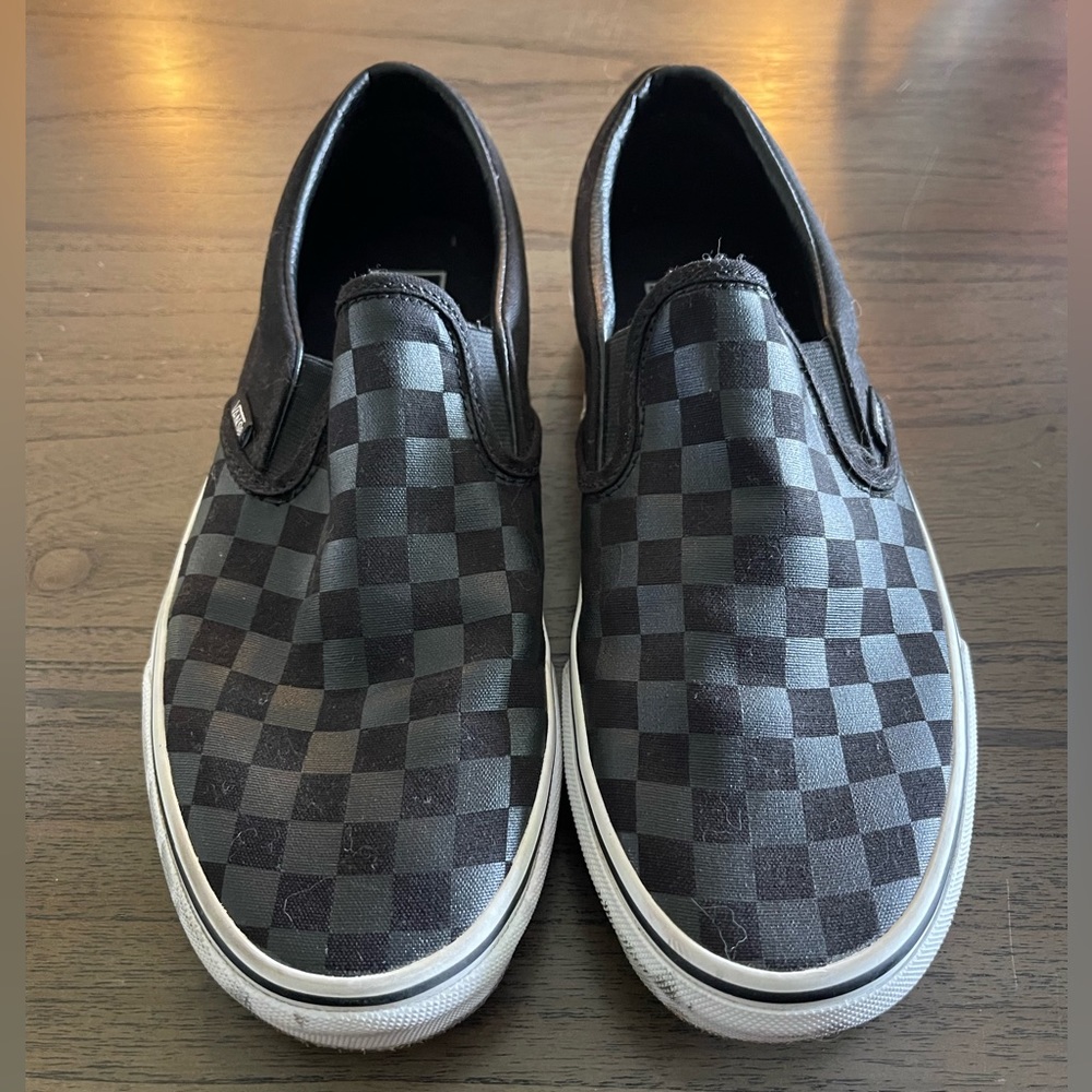 Black on black classic checkerboard slip on vans